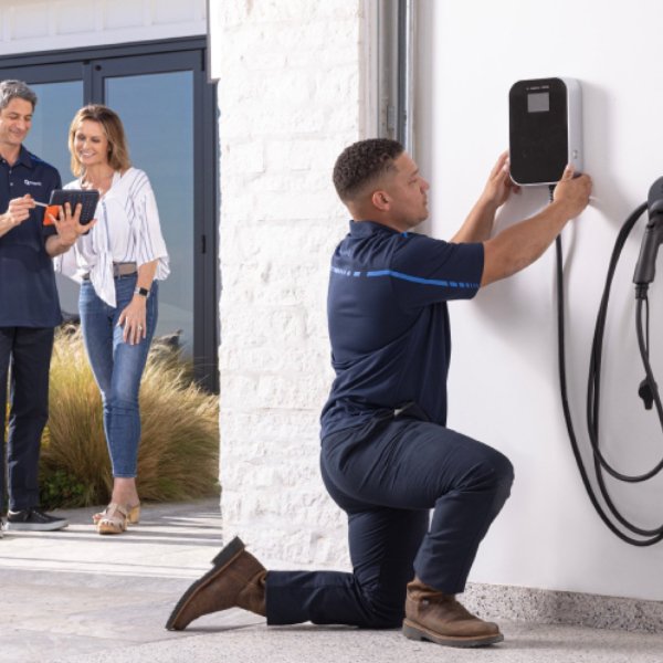 A technician mounting a charger to a wall: in Brisbane CBD
