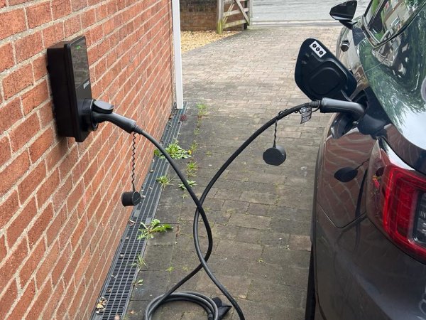 A friendly QMAX Electric technician discussing EV charger installation options with a client in Brisbane CBD.